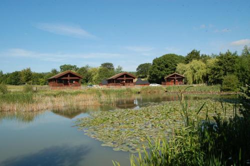 a couple of huts next to a body of water at Watermeadow Lakes & Lodges in North Perrott