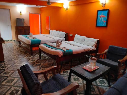 Pokój z 2 łóżkami, krzesłami i stołem w obiekcie Neev Beach View Goa w mieście Anjuna