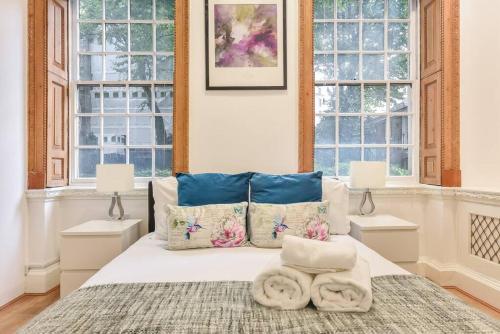 倫敦的住宿－2 Bed Piccadilly Apartment- 2，一间卧室配有一张带两个窗户的床