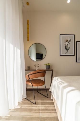 a bedroom with a desk with a mirror and a bed at Samos Tropic Apartments in Ríva