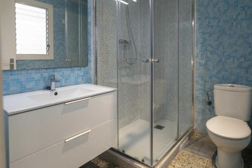 een badkamer met een douche, een toilet en een wastafel bij Suitur apartamento frente a la playa de calafell in Calafell