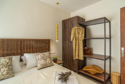 a bedroom with a bed with a wooden headboard and a shelf at Samos Tropic Apartments in Ríva