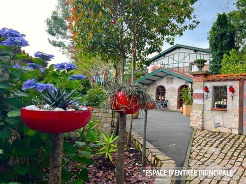 un jardín con flores y una casa de fondo en Villa Merkel - 25 pers - 10 chambr - 9 WC - Piscine en Anglet