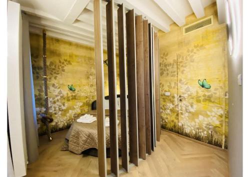 Habitación con cama y pared con mariposas. en Sweet Time Venice, Luxury San Marco Frezzaria apt!, en Venecia