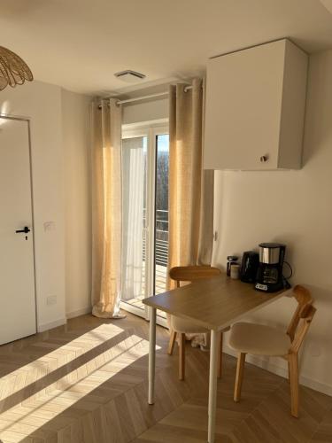 a kitchen with a table and chairs and a window at Studio tout confort Annecy in Annecy