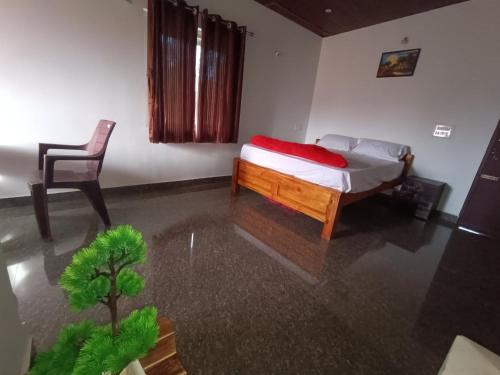 a small bedroom with a bed and a chair at Jishi Homestay in Madikeri