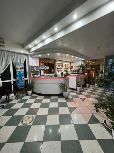 a lobby of a store with potted plants and a counter at Liston Rimini in Rimini
