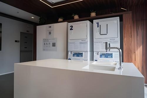 uma cozinha com um balcão branco e um lavatório em Studio 1305 Id Jauaperi em São Paulo