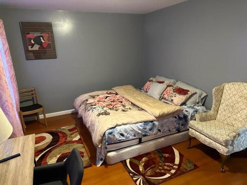 a bed and a chair in a room at Guest House 3 BEDROOM 2 Bathrooms 5 MINS TO EWR NEWARK AIRPORT 4 MINS TO PENN STATION in Newark
