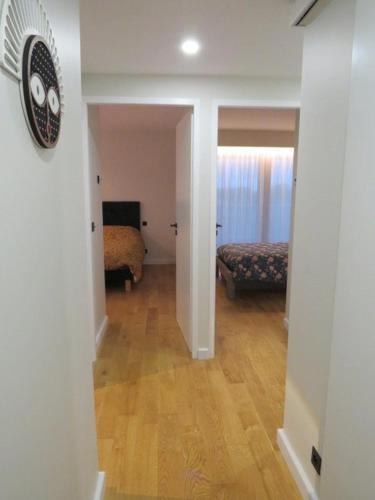 un couloir menant à une chambre avec une horloge sur le mur dans l'établissement Belles prestations pour ce T4 avec vue mer et piscine - 6FLAM701 high-end residence sea view and pool, à Canet