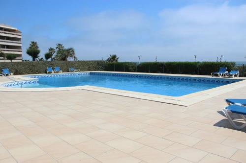 - une piscine dans un complexe avec des chaises bleues et une antenne dans l'établissement Belles prestations pour ce T4 avec vue mer et piscine - 6FLAM701 high-end residence sea view and pool, à Canet