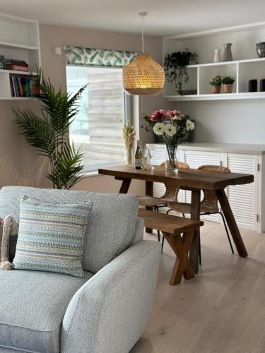 a living room with a table and a couch at Aggie Beach Apartment - Unrivalled Beach Views in St. Agnes