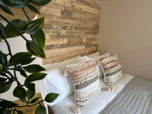 a bedroom with a wooden headboard and pillows on a bed at Aggie Beach Apartment - Unrivalled Beach Views in St. Agnes