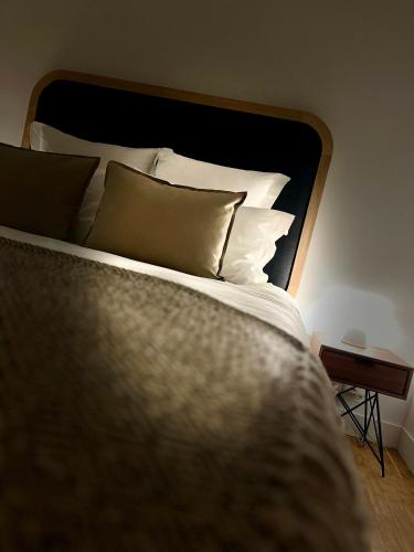 a bed with white pillows and a black headboard at Richard Lequet Domaine gastronomique du Val d Atur in Boulazac