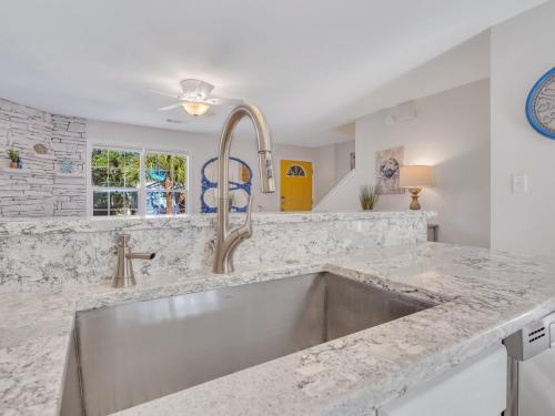 a kitchen with a stainless steel sink in a counter at Peaceful Beach Vacation, Heated Pool Access, Walk to Restaurants & More! in Tybee Island
