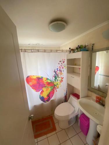 baño con cortina de ducha de mariposa y aseo en Casa en coquimbo, en Coquimbo