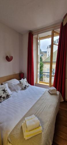 a bedroom with a large bed with two towels on it at Hotel ChezJeanne in La Bourboule