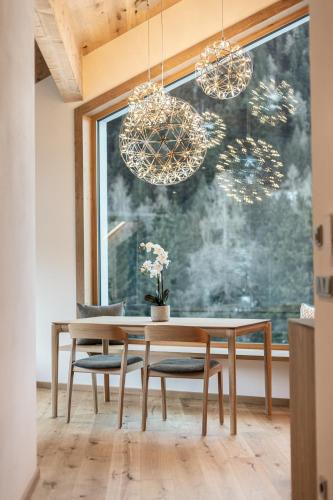 a dining room with a table and chairs and chandeliers at Chalet Samont in Laion