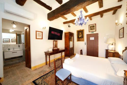 a bedroom with a bed and a tv on the wall at BolognaRoomscom - Ca' Palazzo in Sasso Marconi