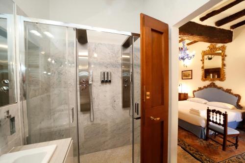 un bagno con doccia e una camera con letto di Cà Palazzo Malvasia - BolognaRooms a Sasso Marconi