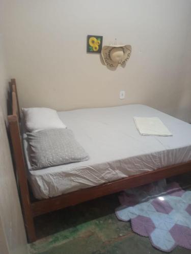 1 cama en un dormitorio con reloj en la pared en A silenciosa en Brasilia