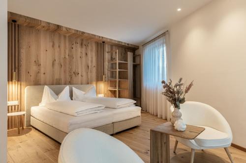 een slaapkamer met een bed en een tafel en stoelen bij Chalet Samont in Laion