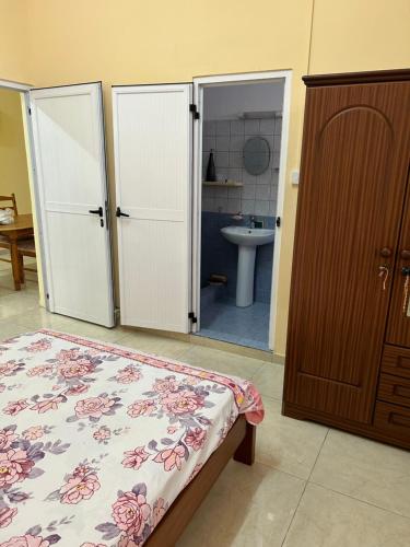 1 dormitorio con 1 cama y baño con lavamanos en VMKY apartment en Triolet
