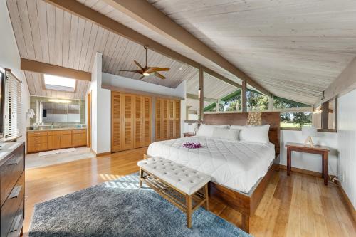 a bedroom with a large bed and a kitchen at Hale Ho'omaha in Princeville