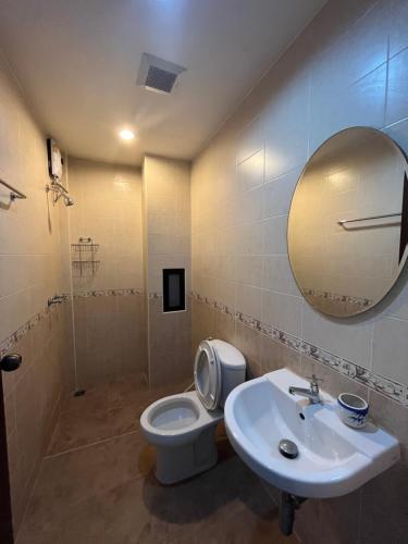 a bathroom with a toilet and a sink and a mirror at Grandmom Place in Krabi