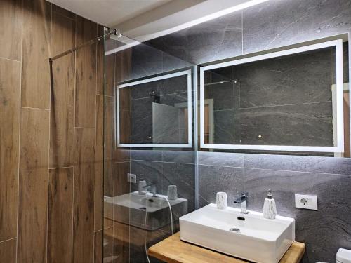 ein Badezimmer mit einem weißen Waschbecken und einem Spiegel in der Unterkunft Urban Vista Apartments in Ohrid