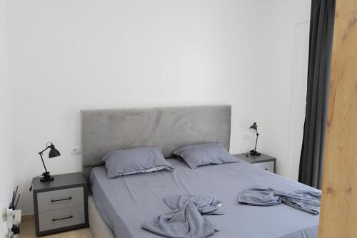 1 dormitorio con 1 cama con 2 toallas en ViVo Beach Apartment, en Durrës