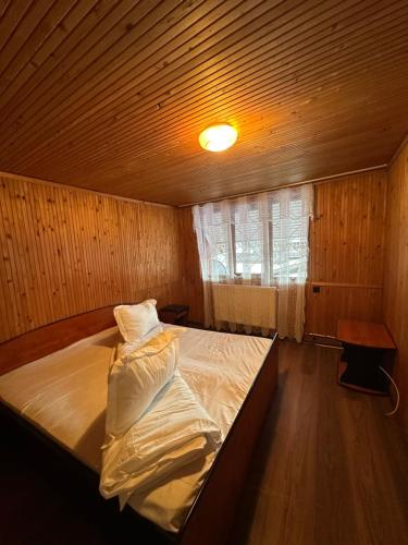 a bedroom with a bed in a wooden room at Pensiunea Stefan in Durău