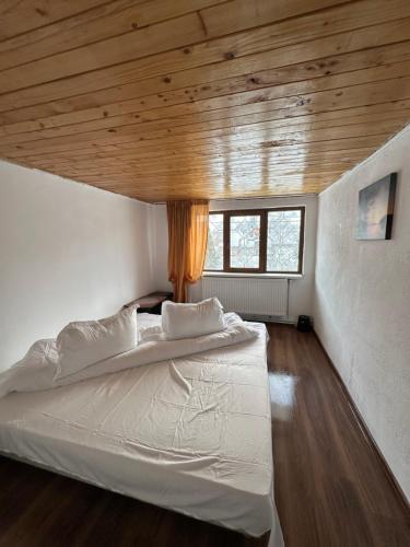 sypialnia z dużym łóżkiem i drewnianym sufitem w obiekcie Pensiunea Stefan w mieście Durău