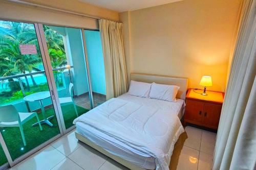 a bedroom with a bed and a balcony with a table at Laguna 1, Marina Island by TZ Homestay in Lumut