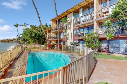 an apartment building with a swimming pool in front of a building at Hono Kai B17 in Wailuku