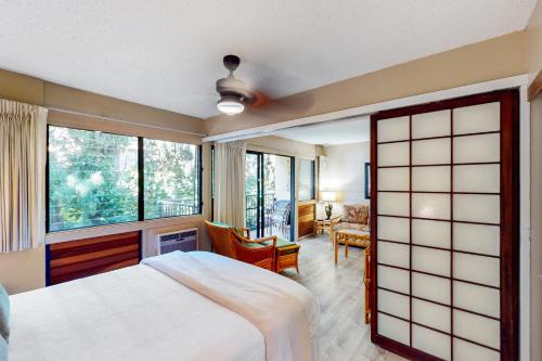 a bedroom with a bed and a large window at Hono Kai B17 in Wailuku