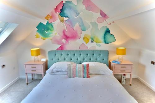 a bedroom with a bed with a flower mural on the wall at Ty Croeso House in Llangattock