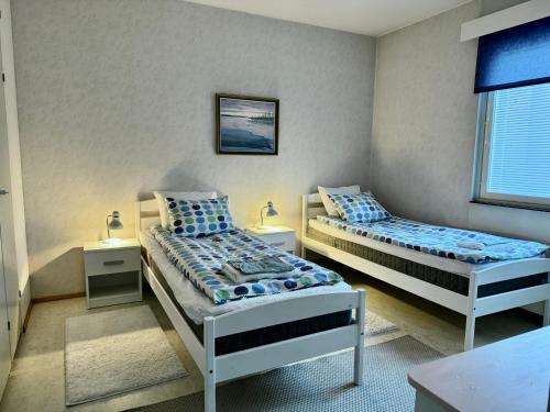 sypialnia z 2 łóżkami i oknem w obiekcie Joensuu keskustaneliö w mieście Joensuu