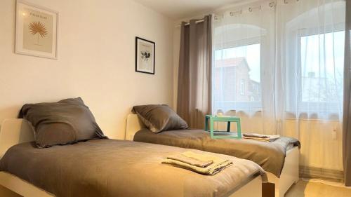 2 camas en una habitación con ventana en Stadion Apartment für 4 Personen en Kassel