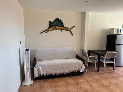 a room with a bed and a table with a fish on the wall at Ocean bleu 972 Orange N 2 in Les Anses-dʼArlets