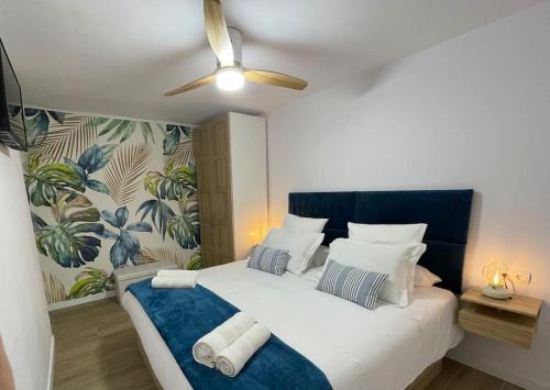 a bedroom with a bed with a ceiling fan at Apartamento centrico junto al mar in Estepona