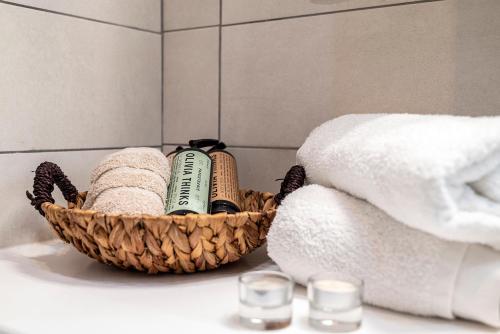 a basket of towels and towels on a sink in a bathroom at Coastal Elegance Suite 1-Min to the Beach in Ampavris