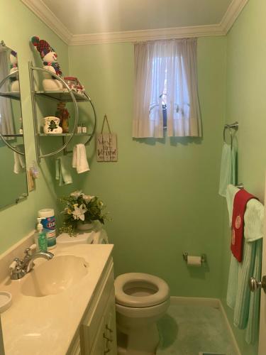 a bathroom with a sink and a toilet and a window at Grandma Sang's Bed & Breakfast 