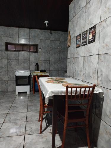 a kitchen with a table and chairs and a stove at Casa espaçosa com Wi-Fi, garagem para 2 veículos e área externa em Campos dos Goytacazes in Campos dos Goytacazes