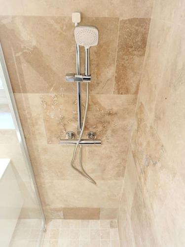um chuveiro na casa de banho com uma cabeça de chuveiro em Appartement Rose em Nogent-sur-Seine