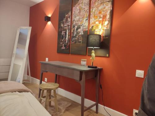 ein Schlafzimmer mit einem Schreibtisch mit einer Lampe in der Unterkunft Appartement Rose in Nogent-sur-Seine
