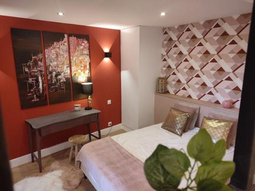ein Schlafzimmer mit einem Bett, einem Tisch und einer Pflanze in der Unterkunft Appartement Rose in Nogent-sur-Seine