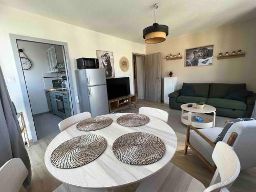 a living room with a table and a couch at Adorable Appartement Strasbourg NEUDORF PARKING SOUS SOL in Strasbourg