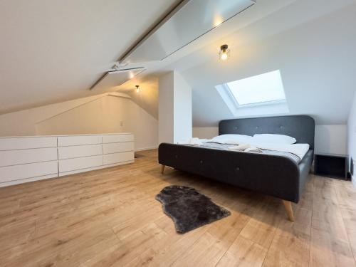 a bedroom with a black bed in a attic at Klassen Apartments! Stadtnahes Ferienhaus* mit Terrasse in Aulendorf * für 6-8 Personen in Aulendorf