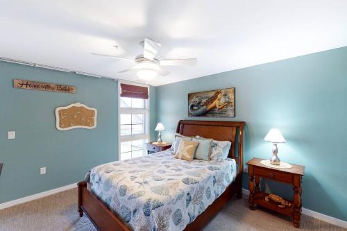 1 dormitorio con cama y pared azul en Sojourn's Penthouse 4 BR Sanctuary Condo, en Virginia Beach